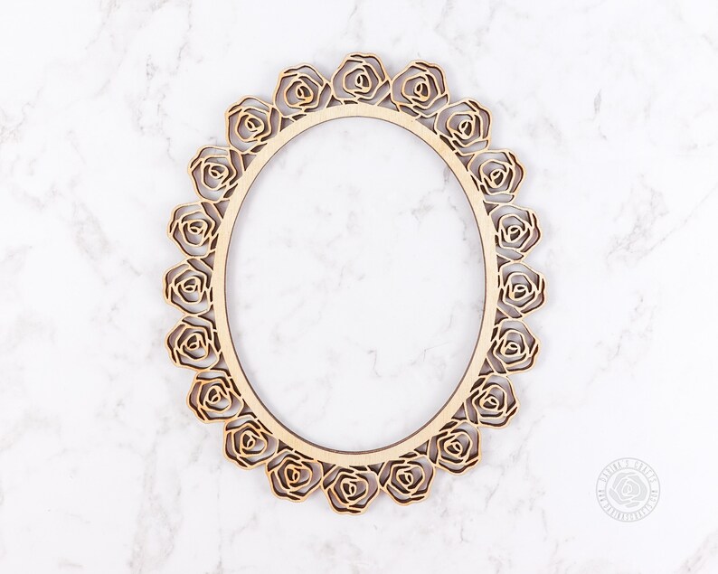 May include: A wooden oval frame with a decorative rose design. The frame is made of light brown wood and has a smooth finish.