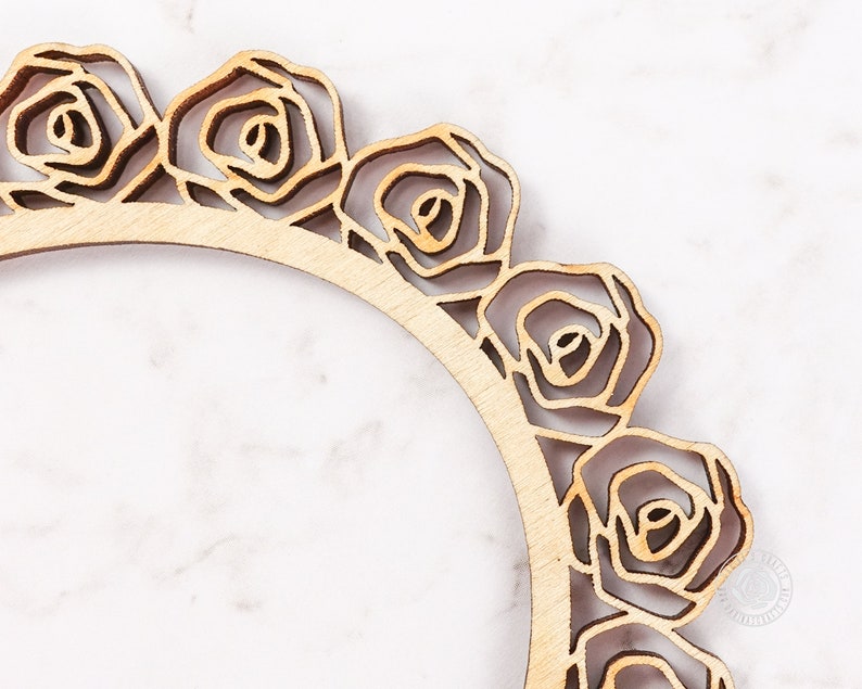 May include: A wooden frame with a decorative rose design. The frame is unfinished and has a natural wood color.