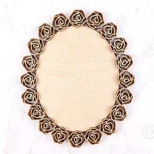 May include: An oval wooden frame with a decorative border of laser-cut roses. The frame is made of light wood and has a natural finish.
