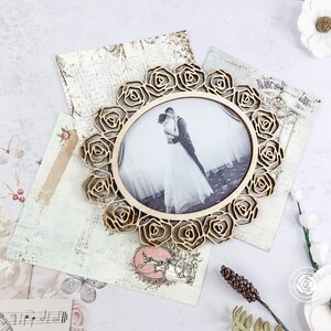 May include: A wooden photo frame with a floral design, featuring a wedding photo of a couple in a garden setting. The frame is a light brown color and has a delicate, intricate design.