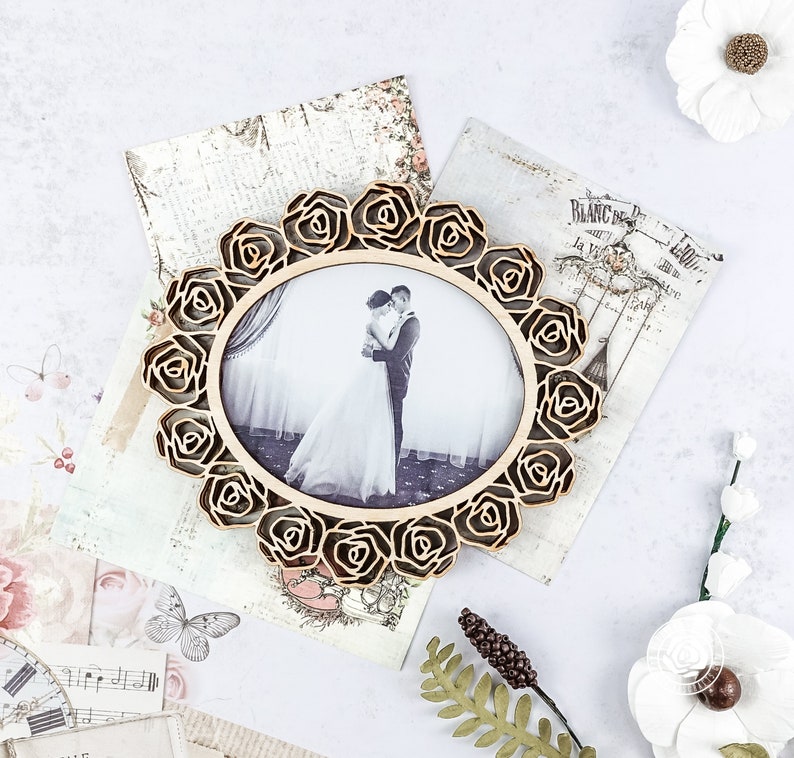 May include: A wooden picture frame with a rose design. The frame is holding a black and white photograph of a couple.