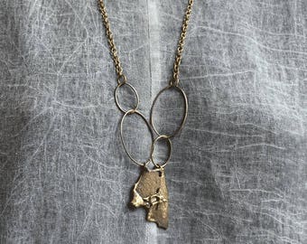 Collier, pendentif en bronze.