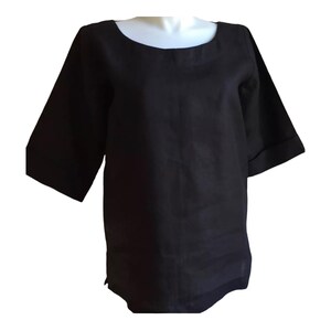 May include: A black linen top with a scoop neck and three-quarter sleeves. The sleeves have a rolled cuff detail.