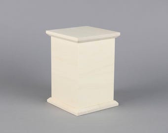 May include: A plain, unfinished wooden box with a square shape. The box is made of light-colored wood and has a simple design.