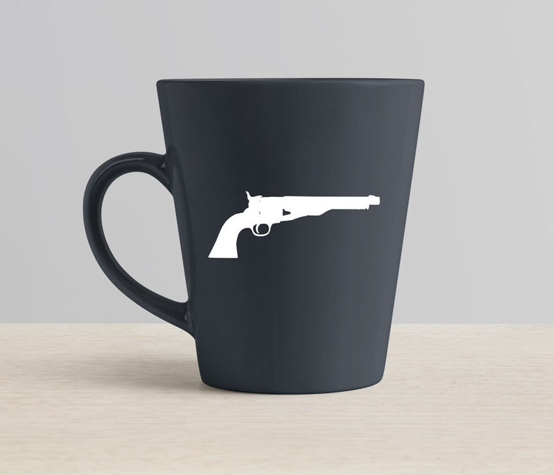 Peut inclure: Une tasse en c&eacute;ramique gris fonc&eacute; avec une silhouette blanche d'un revolver sur le c&ocirc;t&eacute;.