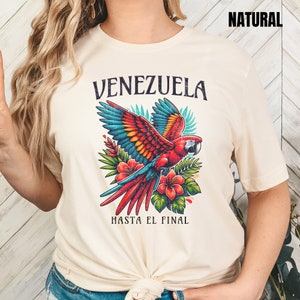 May include: A beige t-shirt with a colorful parrot graphic and the text "Venezuela Hasta El Final".