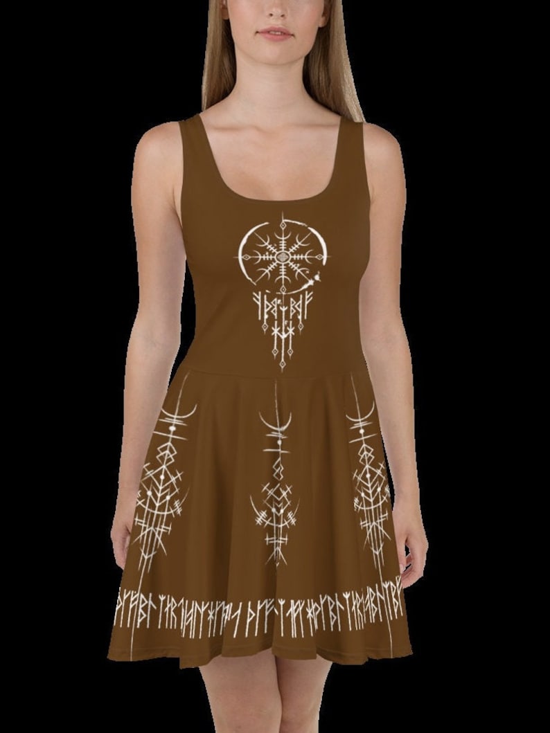 K&ouml;nnte beinhalten: Ein braunes, &auml;rmelloses Kleid mit einem wei&szlig;en Design aus Kompass und Runen. Das Kleid hat einen ausgestellten Rock und einen wei&szlig;en Band aus Runen am Saum.