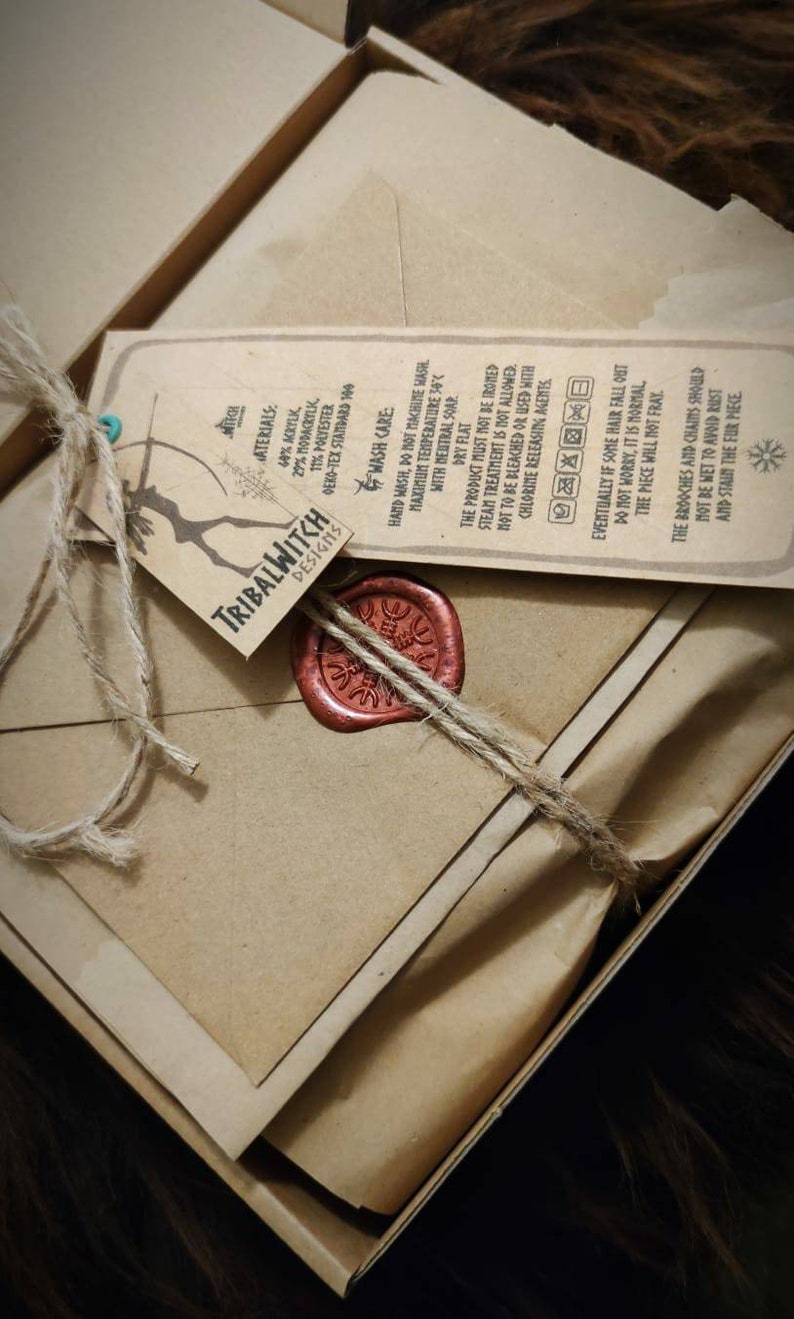 K&ouml;nnte beinhalten: Ein braunes Papierpaket, das mit Schnur gebunden und mit einem roten Wachssiegel versiegelt ist. Das Paket ist mit "Tribalwitch Designs" beschriftet und enth&auml;lt Pflegehinweise f&uuml;r ein Haarst&uuml;ck.