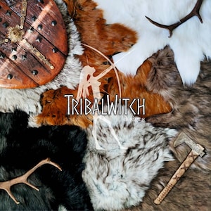 May include: A collection of faux fur hides in various colors and textures, including white, brown, and black. A wooden shield with metal accents and a small axe are also included. The text "TribalWitch designs" is visible in the center of the image.