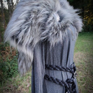 May include: A gray faux fur collar with a silver clasp. The collar is worn over a gray long-sleeved shirt with a black braided belt.