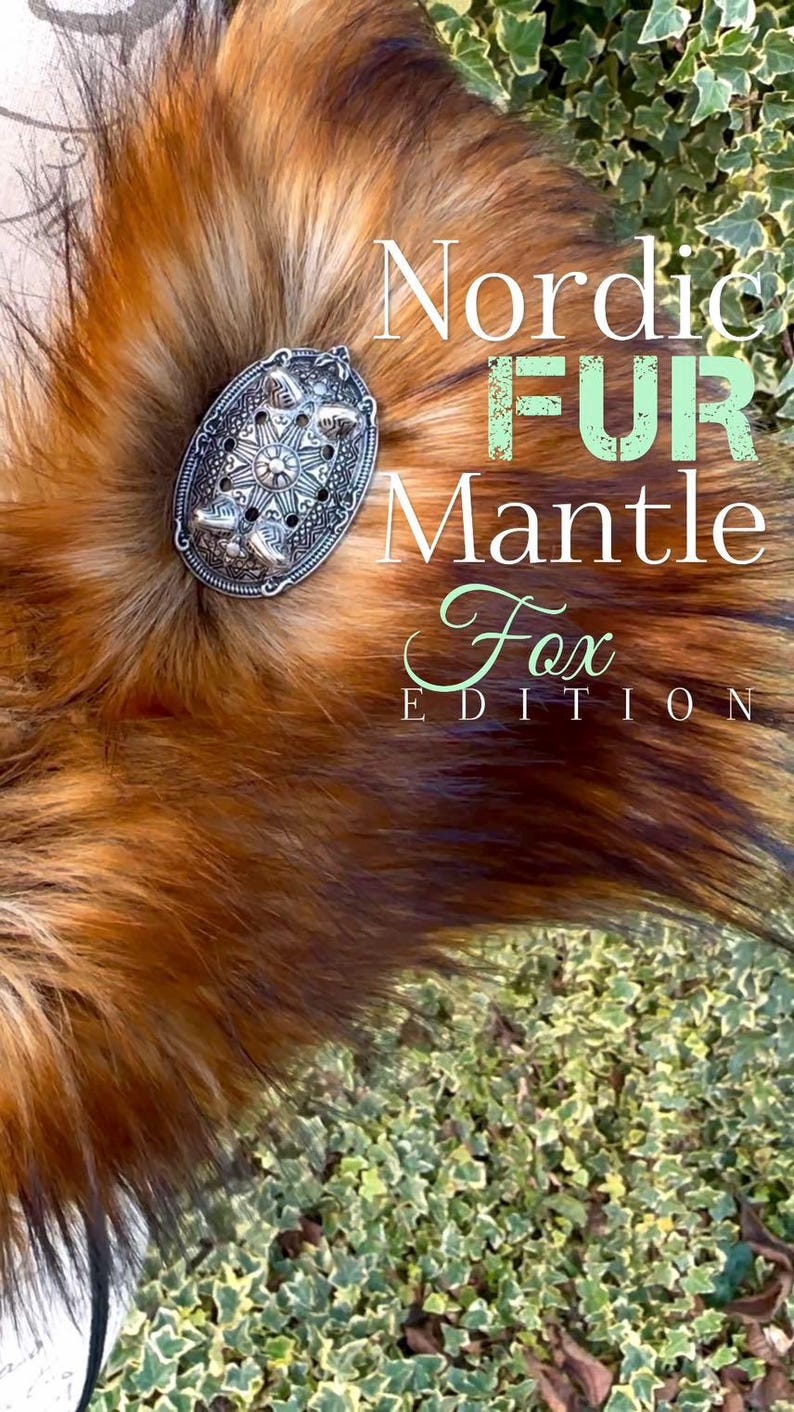 May include: A close-up of a red fox fur mantle with a silver metal clasp. The text "Nordic Fur Mantle Fox Edition" is superimposed on the image.