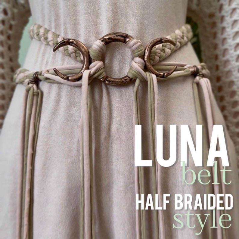 May include: A braided belt with a copper crescent moon buckle. The belt is made of two shades of fabric, a light beige and a light green. The belt is called "LUNA belt HALF BRAIDED style".