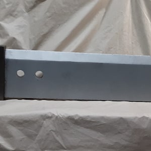 Könnte beinhalten: Ein langes, silberfarbenes Schwert mit einem roten Griff. Das Schwert hat zwei runde Löcher in der Nähe des Griffs.