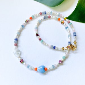 夏にぴったりの17インチのカラフルなビーズネックレス。マルチカラーの淡水パールネックレス。モダンなY2Kネックレスとセラミック製のふっくらとしたハート。ファンキーな90年代のノスタルジア。