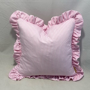 Dusty pink and white woven ticking fabric cushions with frill around them