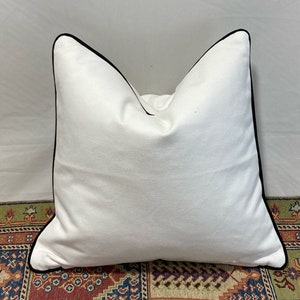 White brushed cotton twill cushions with black piping