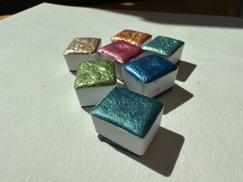 Different colors of sparkly watercolor paints.