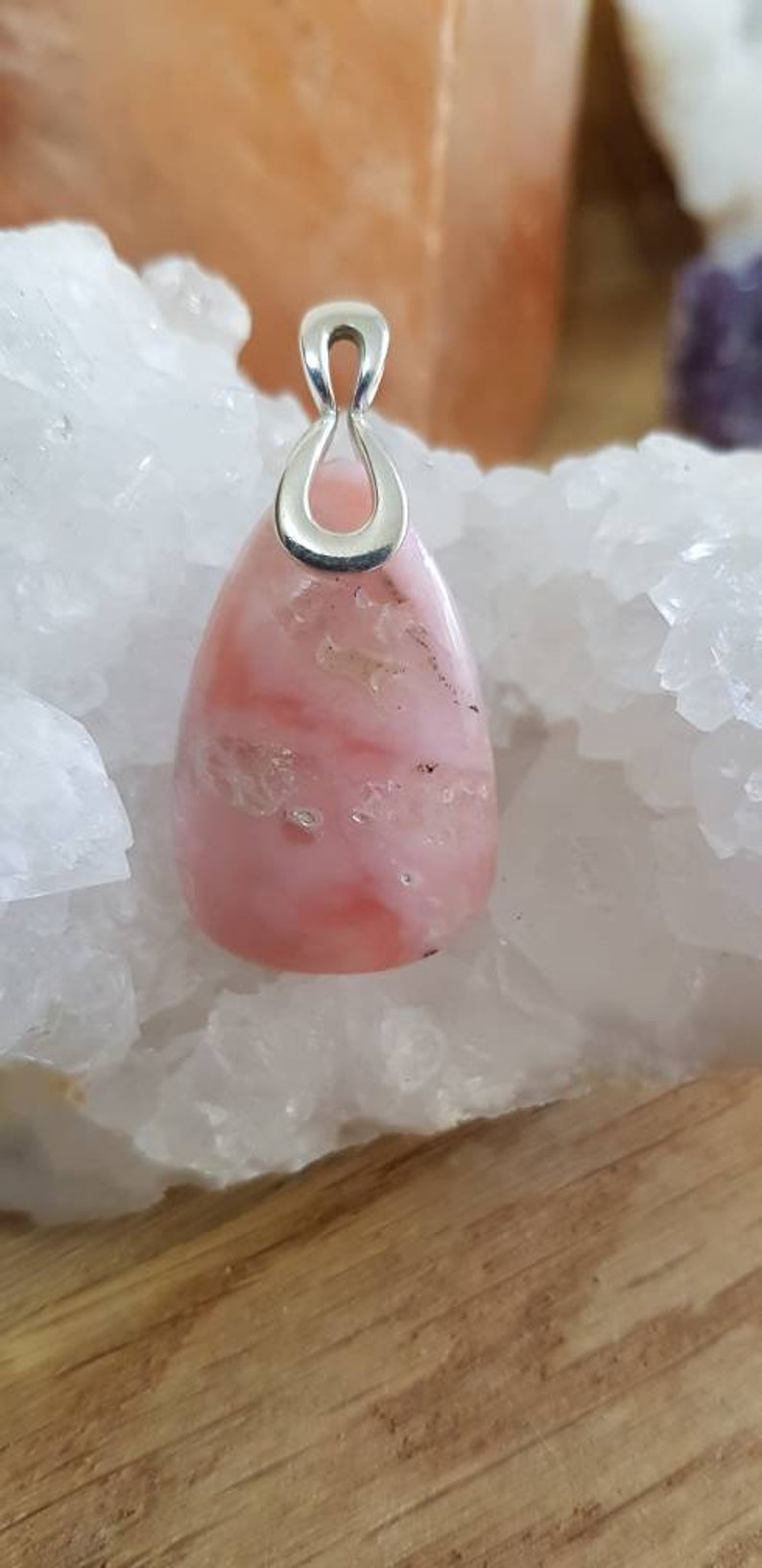 May include: A pink opal pendant with a silver bail. The opal has a swirling pattern of pink and white.