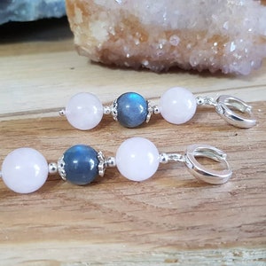 Könnte beinhalten: Ein Paar silberne Creolen mit rosafarbenen und blauen Edelsteinperlen. Die Ohrringe sind aus Rosenquarz und Labradoritperlen gefertigt.