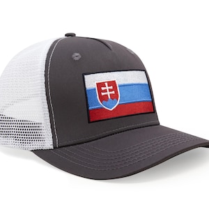 Pode incluir: Boné de beisebol cinza com parte traseira em malha branca e aba curva. A frente apresenta um patch retangular com a bandeira eslovaca, exibindo uma cruz branca sobre um fundo vermelho, azul e branco. O boné tem um design estruturado.