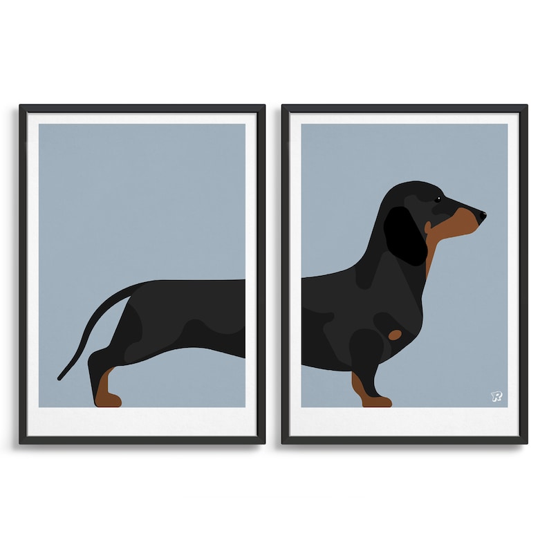 May include: Two framed wall art prints featuring a stylized black and tan dachshund illustration split across both frames. The dog has a long body, short legs, and a smooth coat, set against a solid light blue background with a small white R logo.