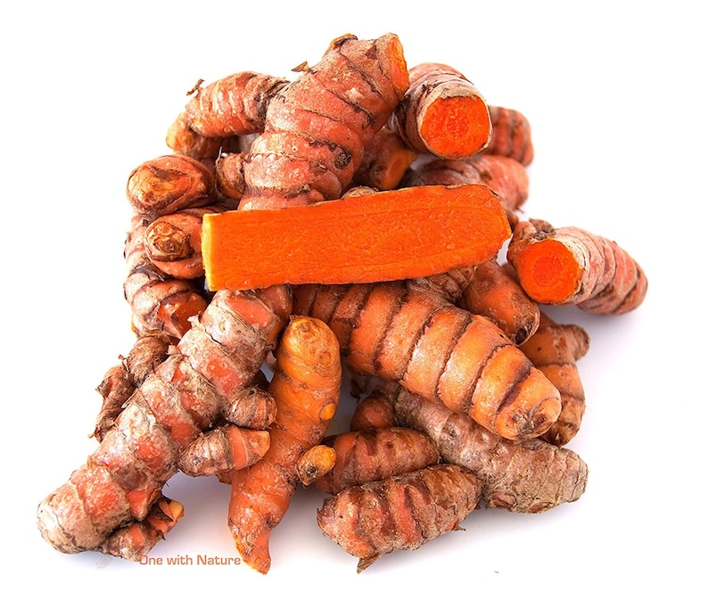 Op de afbeelding: Een stapel verse kurkumawortels, met een levendig oranje binnenkant en een ruwe, bruine buitenkant. E&eacute;n wortel is doorgesneden, waardoor de heldere kleur zichtbaar wordt. De afbeelding is tegen een schone witte achtergrond geplaatst.