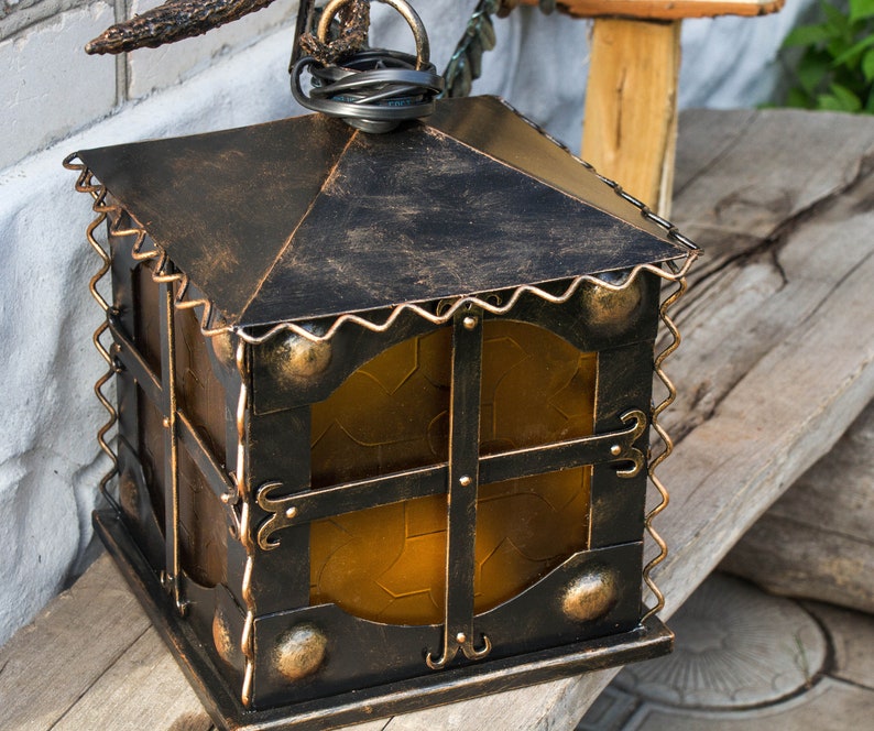 Wrought sconce in the form of an oak branch on which an owl sits with a lantern