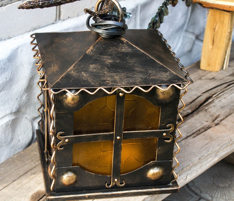 Wrought sconce in the form of an oak branch on which an owl sits with a lantern