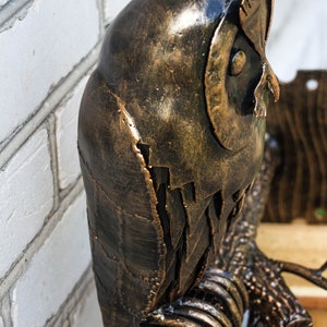 Wrought sconce in the form of an oak branch on which an owl sits with a lantern