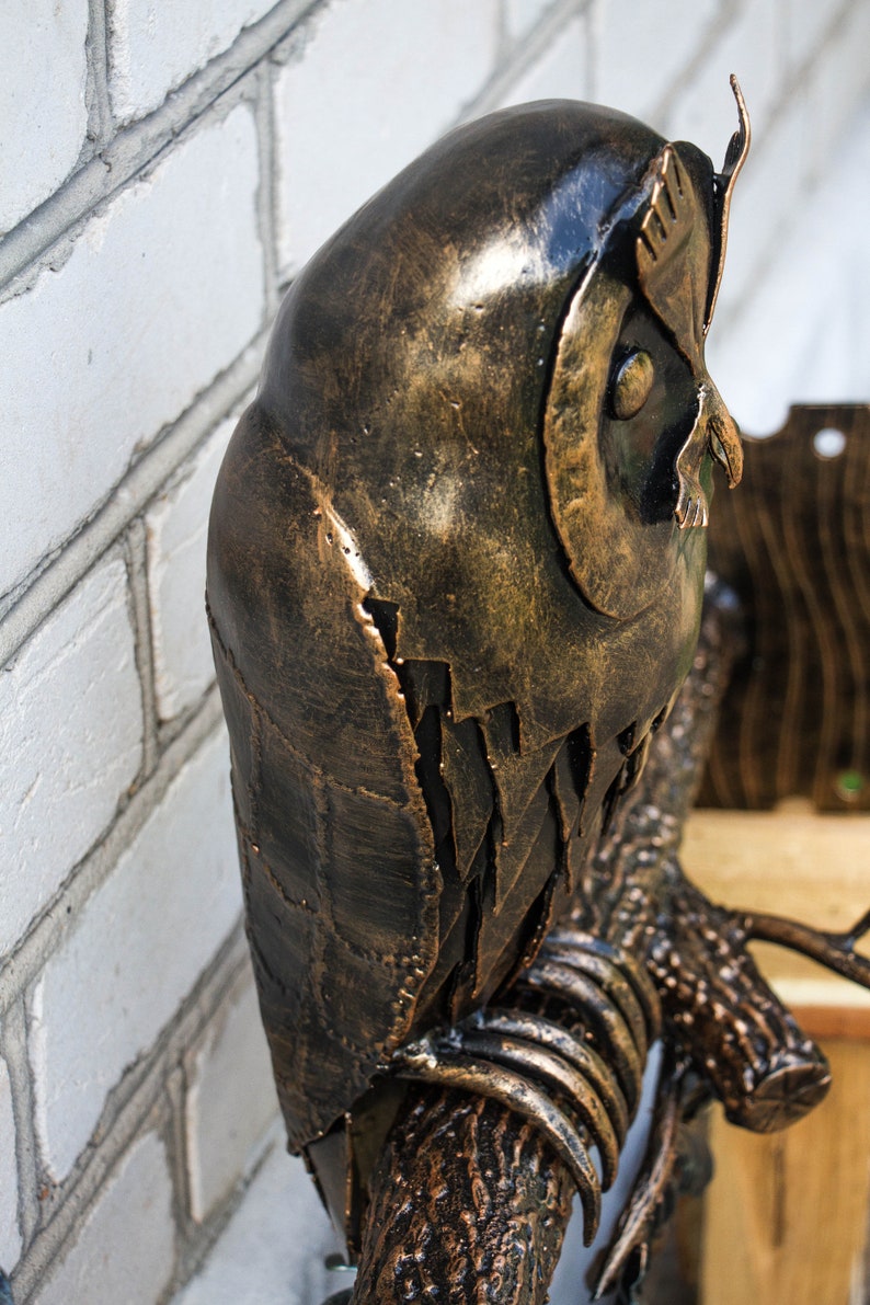 Wrought sconce in the form of an oak branch on which an owl sits with a lantern