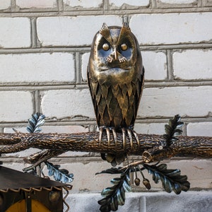 Wrought sconce in the form of an oak branch on which an owl sits with a lantern