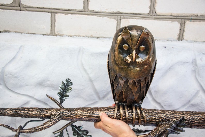 Wrought sconce in the form of an oak branch on which an owl sits with a lantern