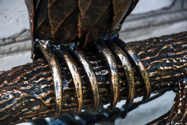 Wrought sconce in the form of an oak branch on which an owl sits with a lantern