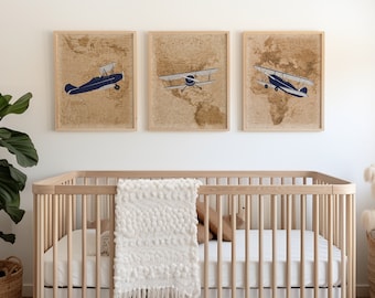 May include: A white crib with a white crocheted blanket and a brown stuffed animal. Three framed prints of vintage airplanes hang on the wall above the crib.