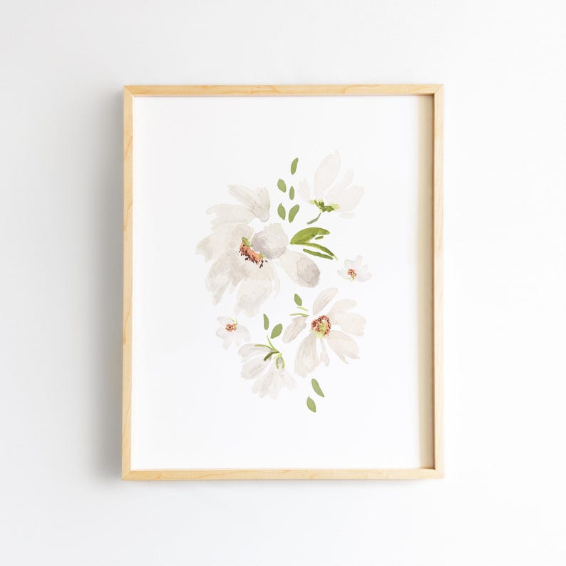 May include: A framed watercolor print featuring a cluster of white flowers with delicate petals and green leaves. The artwork is set against a white background, and the frame is made of light-colored wood.