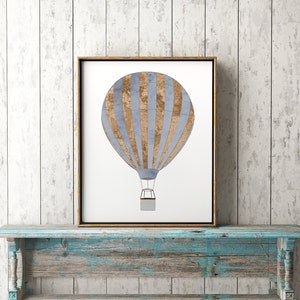 May include: A framed print of a blue and brown hot air balloon with stripes. The balloon is against a white background.
