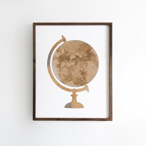 May include: A framed print of a brown and beige globe on a stand. The globe is a watercolor illustration of the world.
