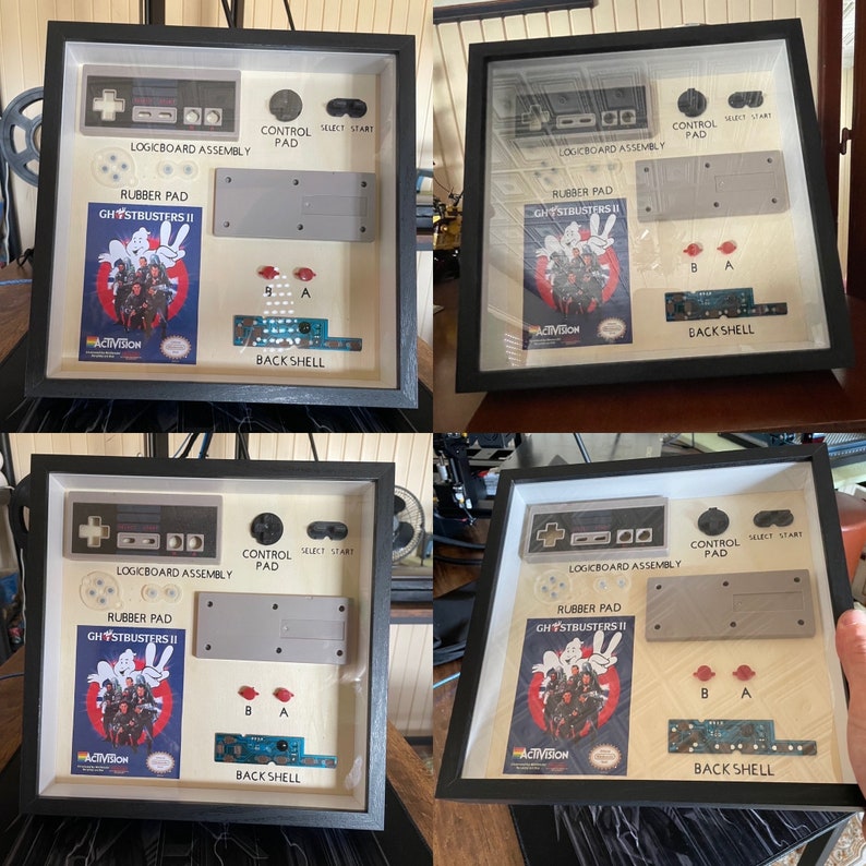 以下が含まれることがあります： 任天堂エンターテインメントシステム（NES）コンソールのコンポーネントを特徴とする額入りのシャドウボックス。 ゴーストバスターズIIのゲームボックス、コントローラーパーツ、その他の要素が含まれています。 黒いフレーム内の明るい背景に配置されています。