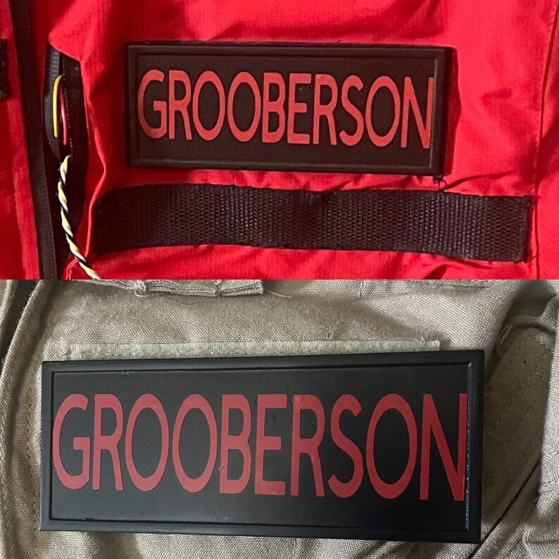 May include: Two black rectangular patches with the name "GROOBERSON" in red lettering. One patch is on a red jacket, the other on a khaki uniform. The patches are likely name tags or identification badges.