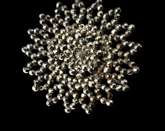 Spilla antica georgiana in acciaio tagliato a forma di ruota floreale.