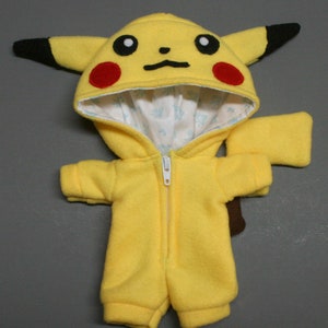 May include: Yellow Pikachu plush toy wearing a yellow hooded jumpsuit with a zipper. The hood has black ears and red cheeks. The jumpsuit has a white lining.
