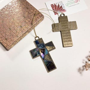 Peut inclure: Deux ornements en forme de croix dor&eacute;s. Une croix est faite de mosa&iuml;ques de verre en bleu, violet et or. L'autre croix est en or massif avec une surface textur&eacute;e.