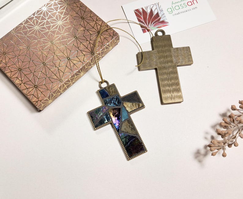 Peut inclure: Deux ornements en forme de croix dor&eacute;s. Une croix est faite de mosa&iuml;ques de verre en bleu, violet et or. L'autre croix est en or massif avec une surface textur&eacute;e.