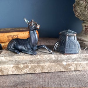 Peut inclure: Un ensemble d'encrier vintage avec une figurine de cerf en bronze et un encrier géométrique sur une base en marbre.
