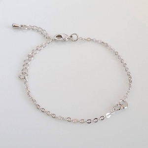 May include: A silver chain bracelet with a delicate heart charm.