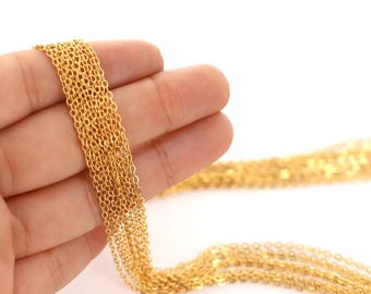 May include: A close-up of a gold chain, held in a hand. The chain is made of small, linked circles and is very delicate.