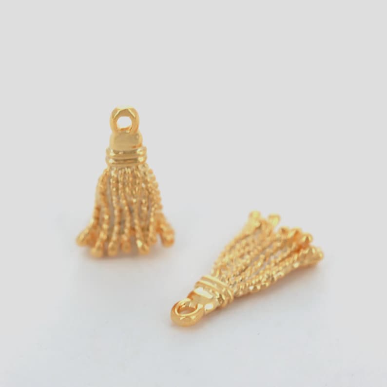 Close-up of shiny gold plated tassel pendant showing smooth polished finish.