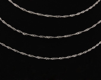 May include: Three silver chains of varying lengths, all with a twisted rope design, are displayed against a black background.