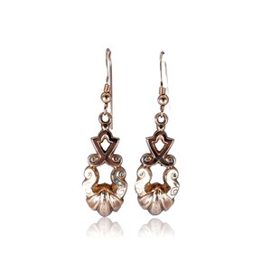 May include: A pair of silver-toned drop earrings. Each earring features an ornate design with a decorative top, a central openwork element, and a lower, shell-like shape. The earrings are suspended from a simple hook.