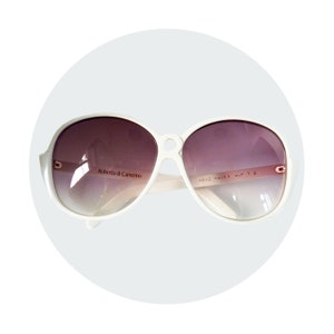 Op de afbeelding: Witte ovale zonnebril met een bruine, verlopende lens. De zonnebril heeft de tekst "Roberta di Camerino" en "Hand Made Italy" op de pootjes.